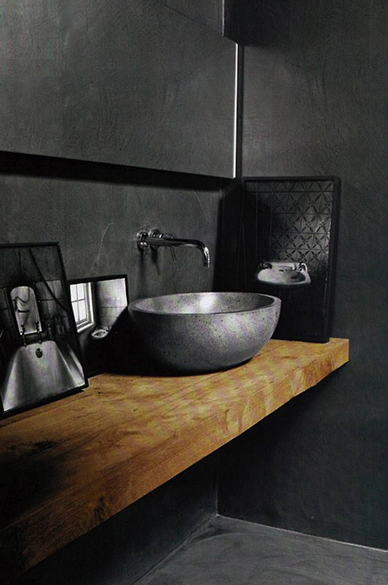 Timber worktop and black countertop basin against a dark wall