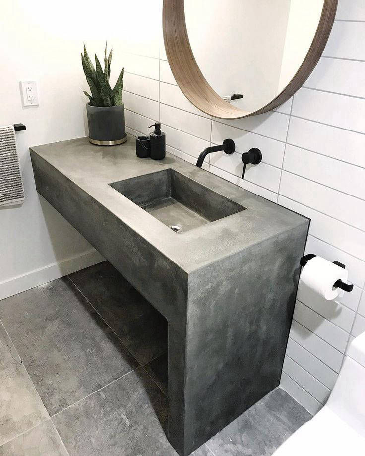 Grey basin unit with an open lower shelf and round mirror
