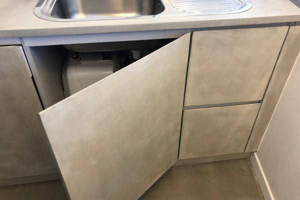 Beige finish on an open cupboard door beneath a sink