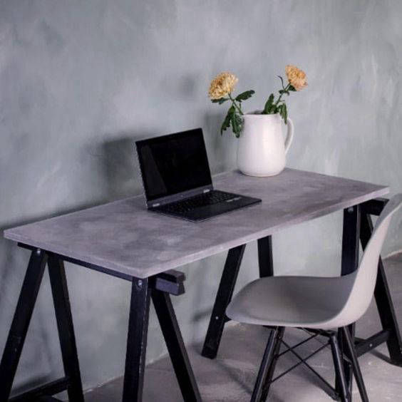 Desk with a laptop in front of a grey wall