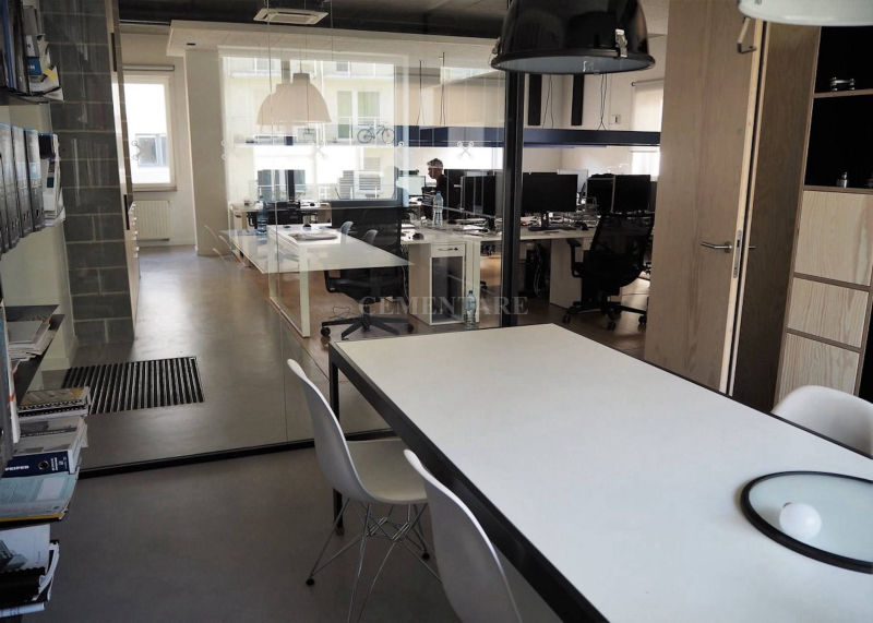 White desks and grey flooring in a glazed workspace