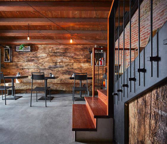Grey restaurant flooring with brick walls and a timber ceiling